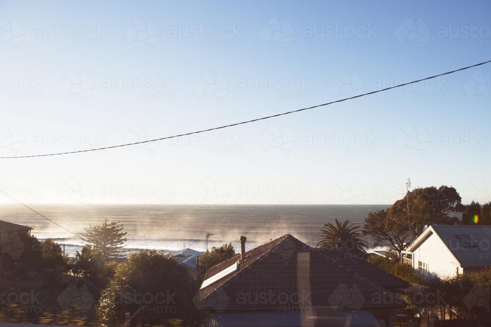 Early morning view of the beach over rooftops - Australian Stock Image