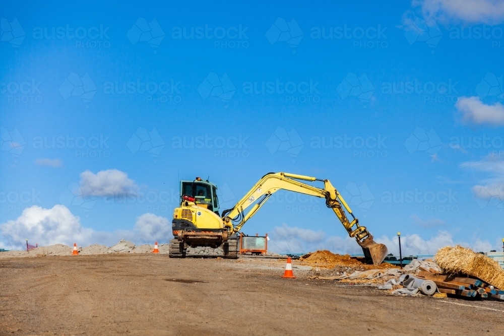 Earth moving machinery working on a construction site scooping soil - Australian Stock Image
