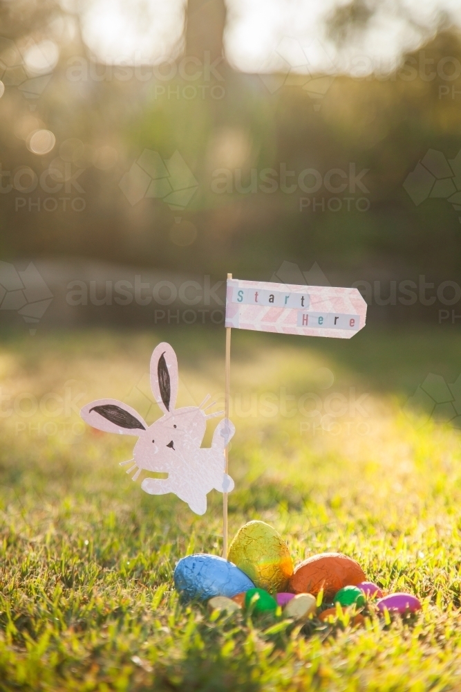 Easter bunny with start here sign at the beginning of an Easter egg hunt - Australian Stock Image