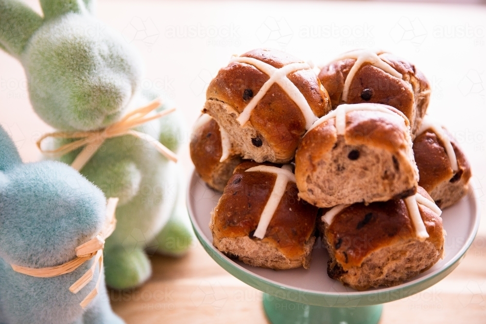 easter hot cross buns in a pile with easter bunny decor - Australian Stock Image
