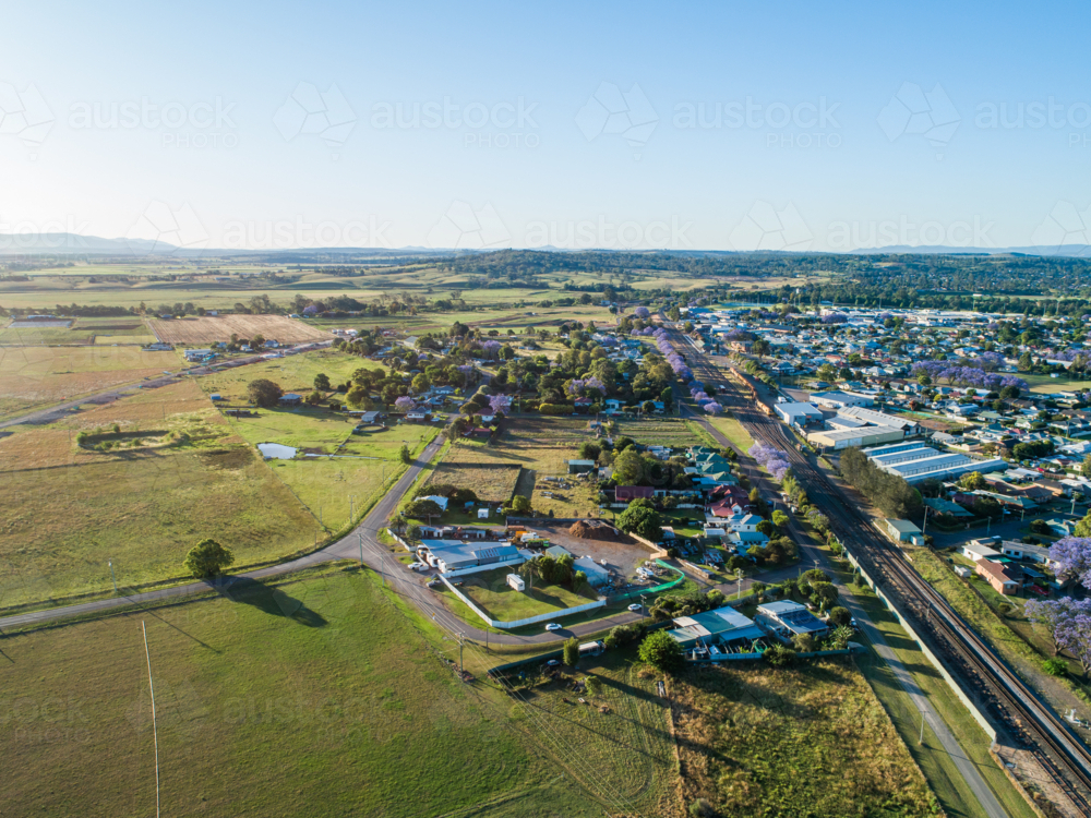 Edge of country town in Australia in early summer with railway line and houses becoming farmland - Australian Stock Image