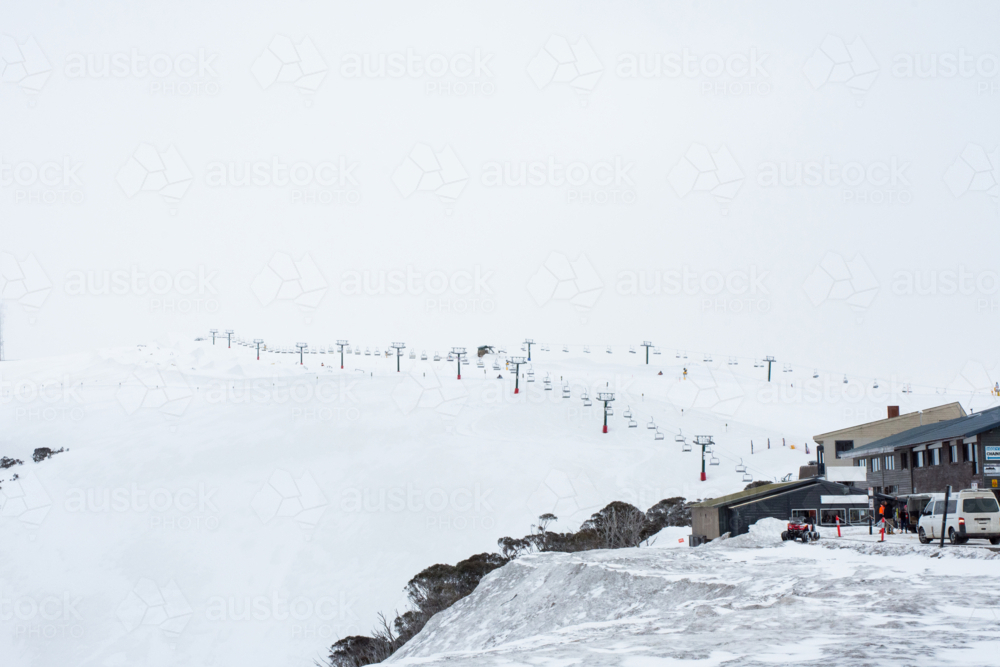 Edge of ski village with ski lift in distance - Australian Stock Image