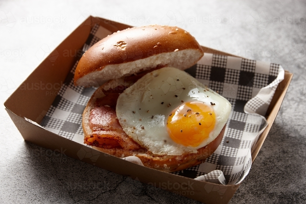 Egg and bacon roll in cardboard tray - Australian Stock Image