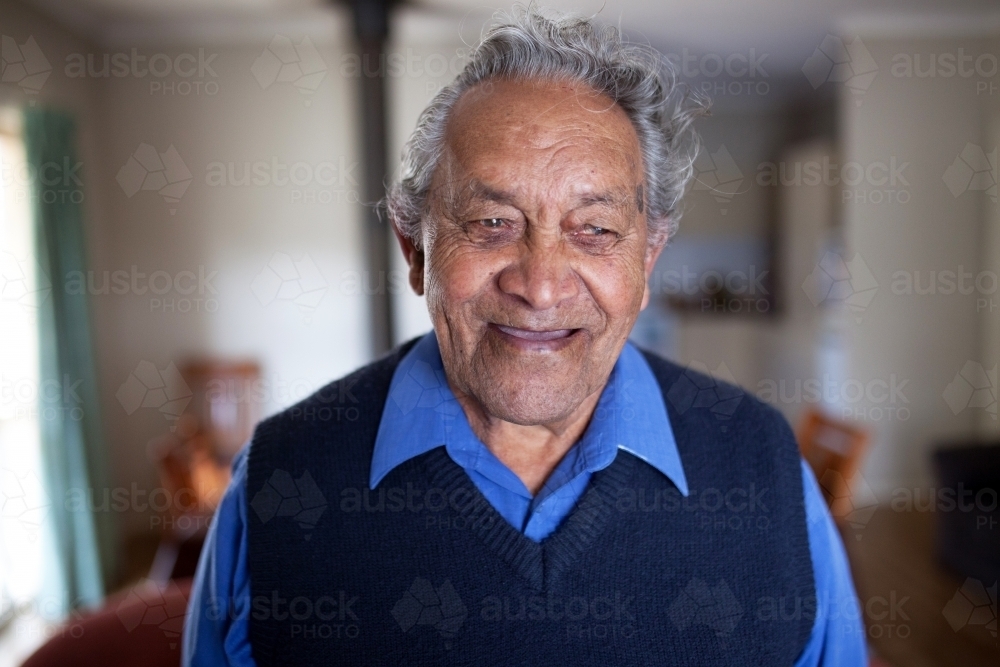 Elderly aboriginal man smiling man at home - Australian Stock Image