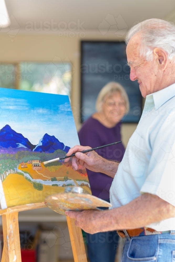Elderly couple painting in art studio - Australian Stock Image