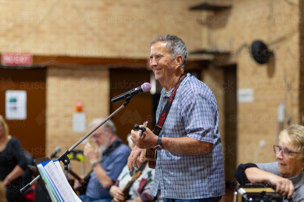 elderly gentleman enjoying singing and playing his ukulele - Australian Stock Image