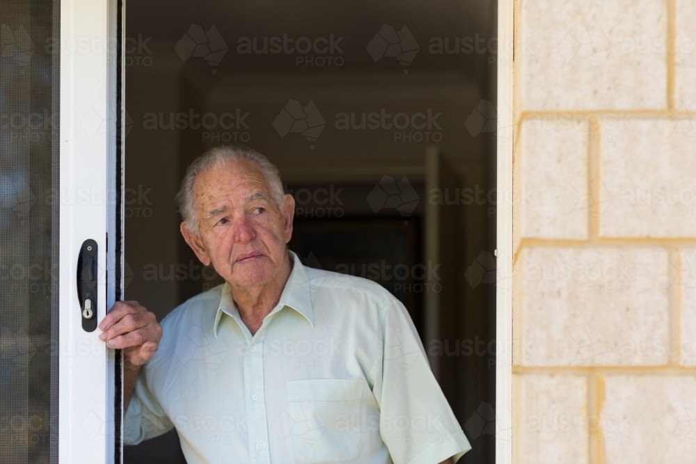 Elderly gentleman looking out of doorway - Australian Stock Image