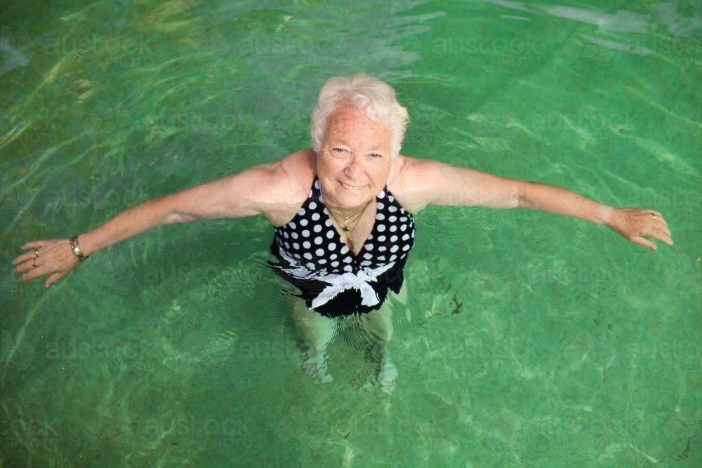 Elderly lady relaxing in a swimming pool - Australian Stock Image