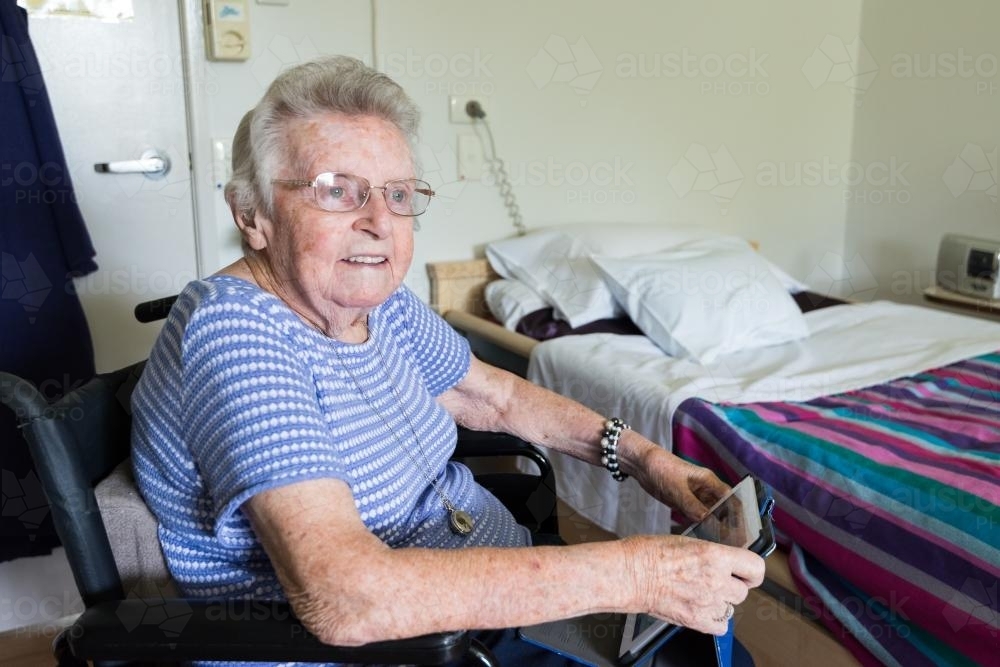 Elderly lady with tablet in nursing home - Australian Stock Image