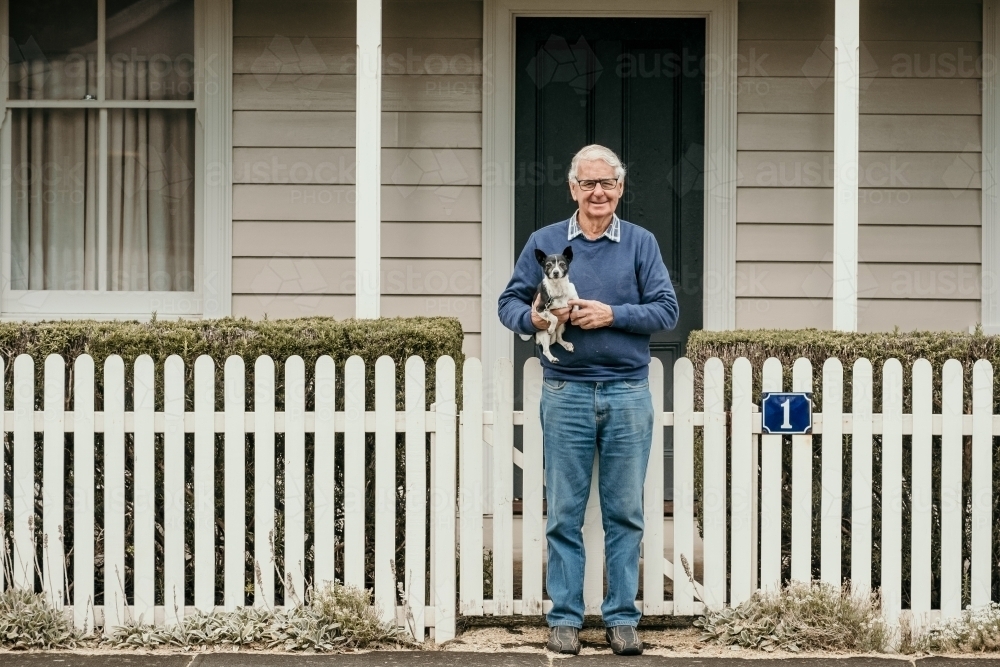 Elderly man and dog walking in the street. - Australian Stock Image
