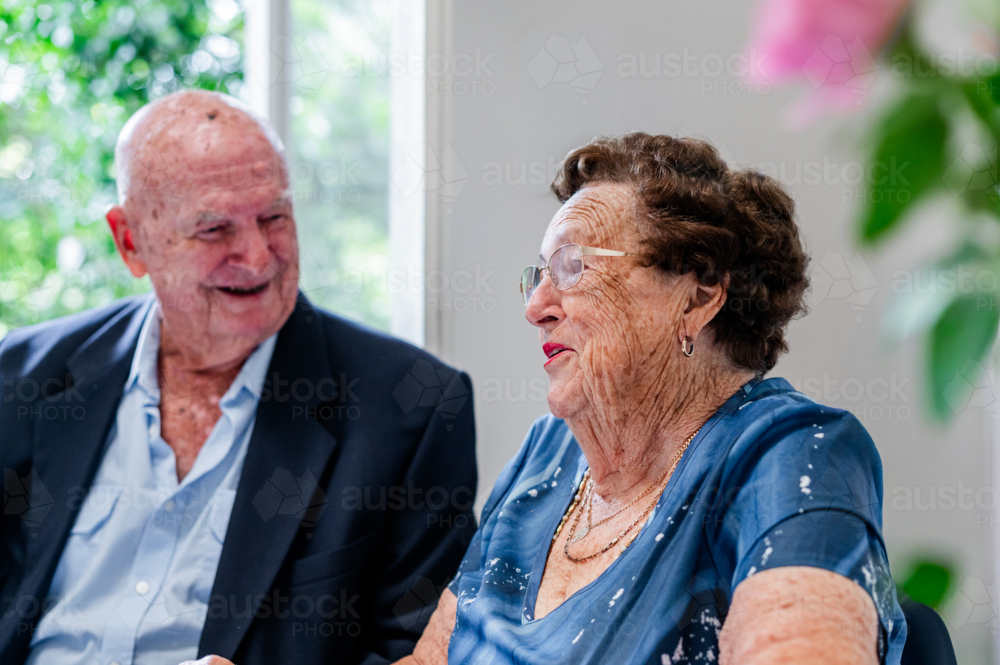 Elderly man and woman sharing a conversation while seated at the table - Australian Stock Image
