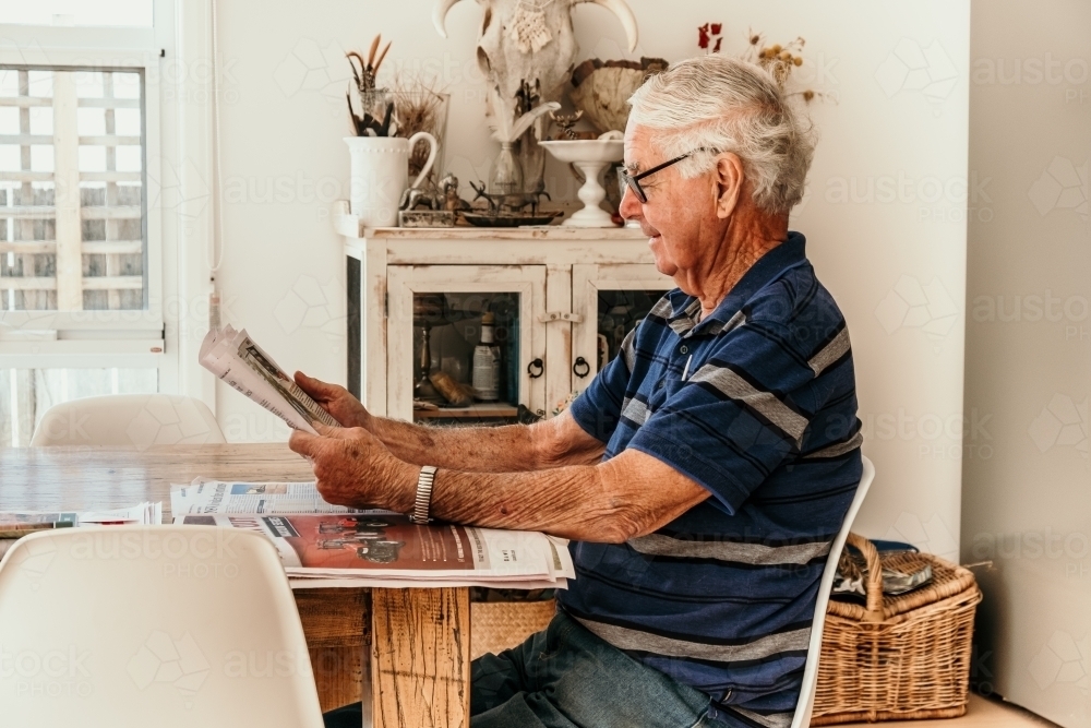 Elderly man reading the daily newspaper. - Australian Stock Image