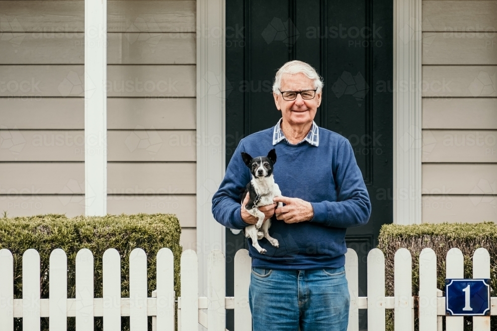 Elderly man with small dog in the street. - Australian Stock Image
