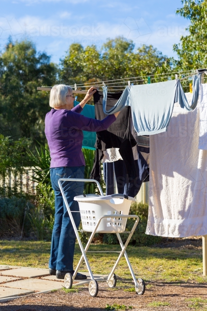 Elderly woman at clothes line with laundry trolley - Australian Stock Image