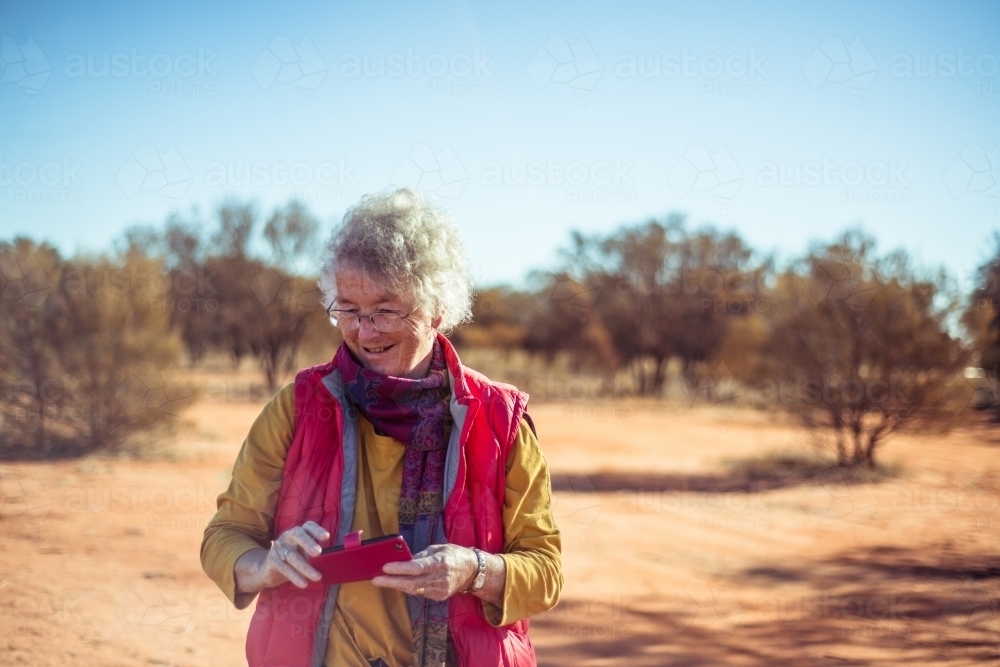 Elderly woman with phone in the Northern Territory - Australian Stock Image