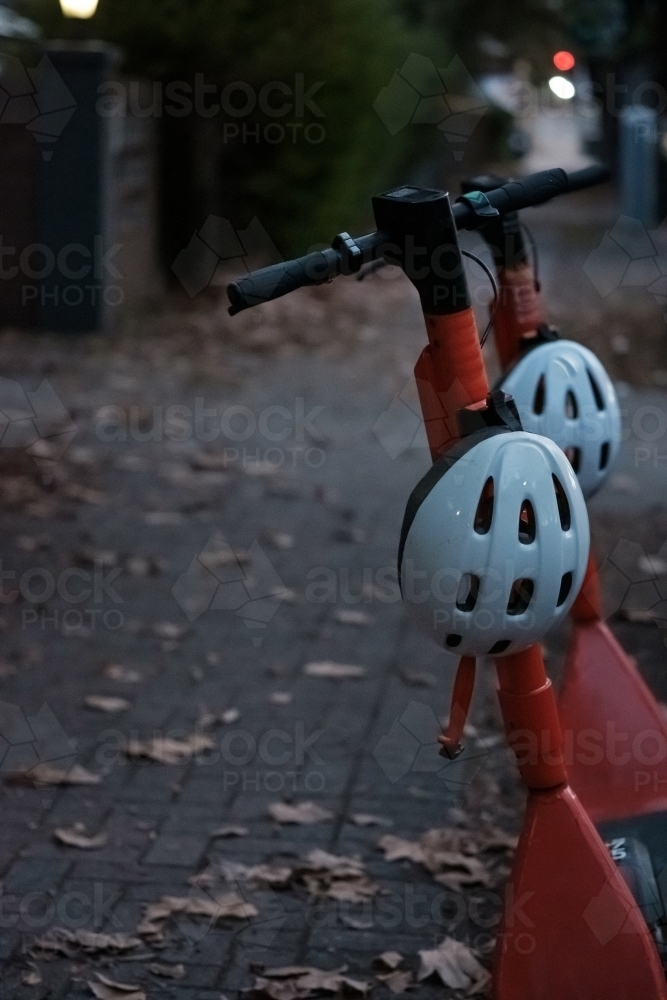 Electric Scooters in a city street with Autumn Leaves - Australian Stock Image