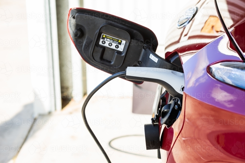 Image of Electric vehicle car charging at home in shed Austockphoto