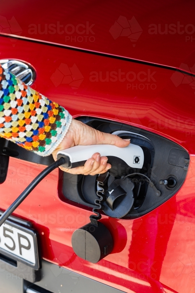 Image of Electric vehicle charging plug being plugged in to car