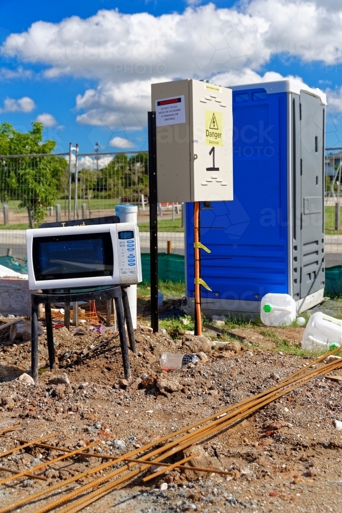 Electrical appliances exposed to the elements, on a chair at a new construction site - Australian Stock Image