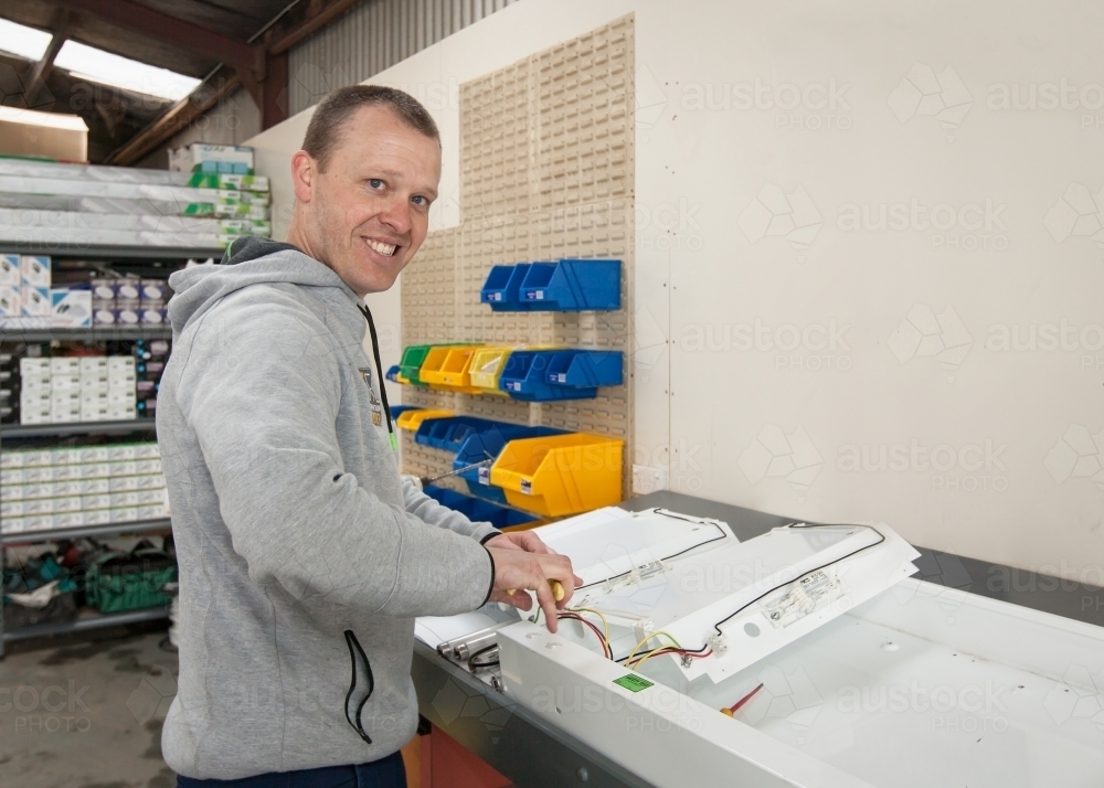 Electrican rewiring a power board in his workshed - Australian Stock Image