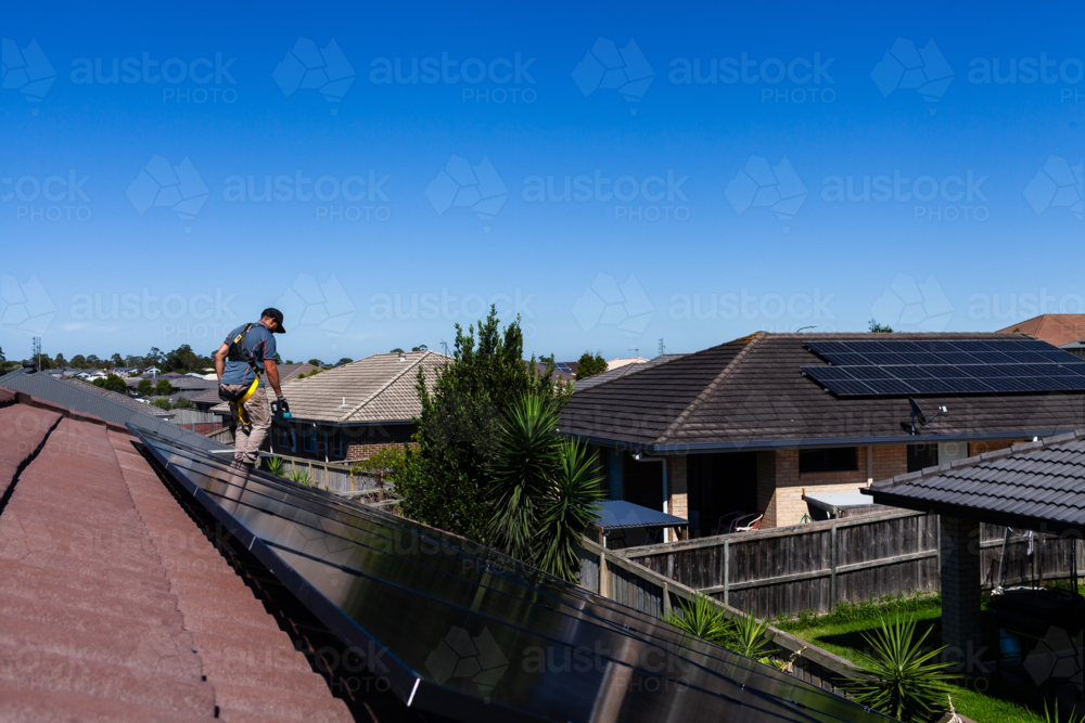 Image of Electrician tradie cleaning up after solar panel installation ...