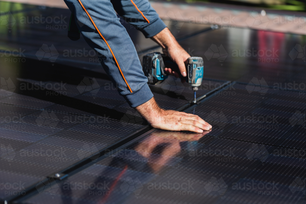 Image of Electrician tradie man clamping down bifacial solar panels on ...