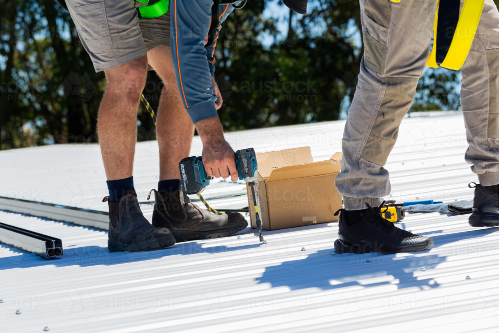 Image of Electrician tradie worker man on roof of suburban house ...