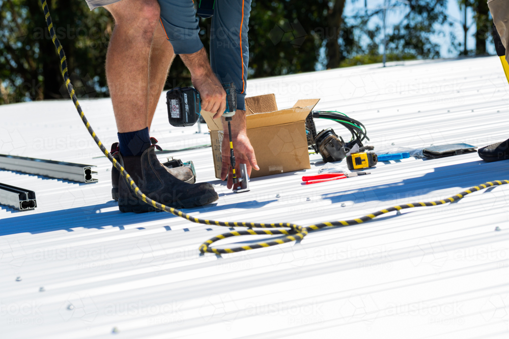 Image of Electrician tradie worker man on roof of suburban house ...