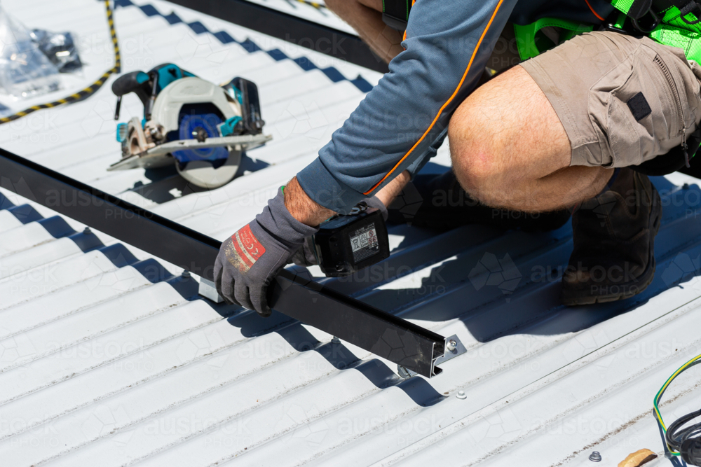 Image of Electrician tradie worker man on roof of suburban house ...