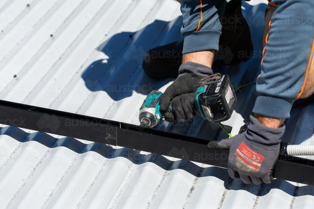 Image of Electrician tradie worker man on roof of suburban house ...