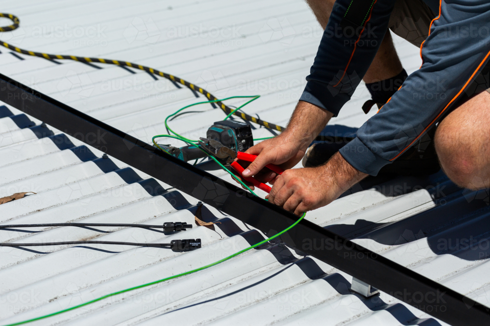 Image of Electrician tradie worker man on roof of suburban house ...