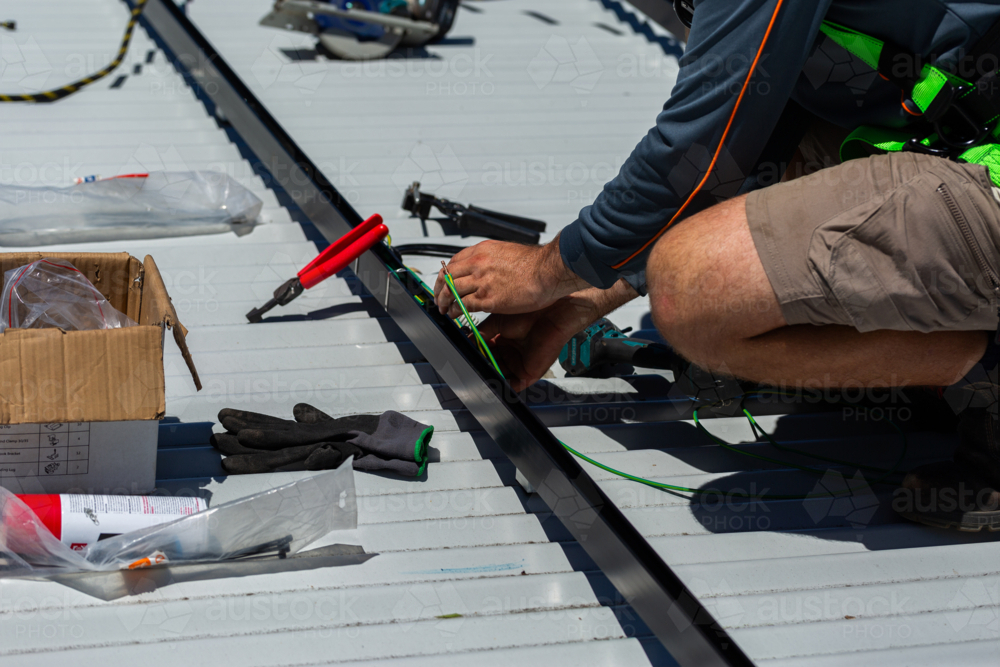 Image of Electrician tradie worker man on roof of suburban house ...
