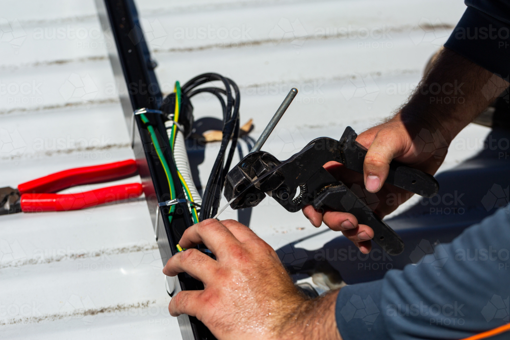 Image of Electrician tradie worker man on roof of suburban house ...