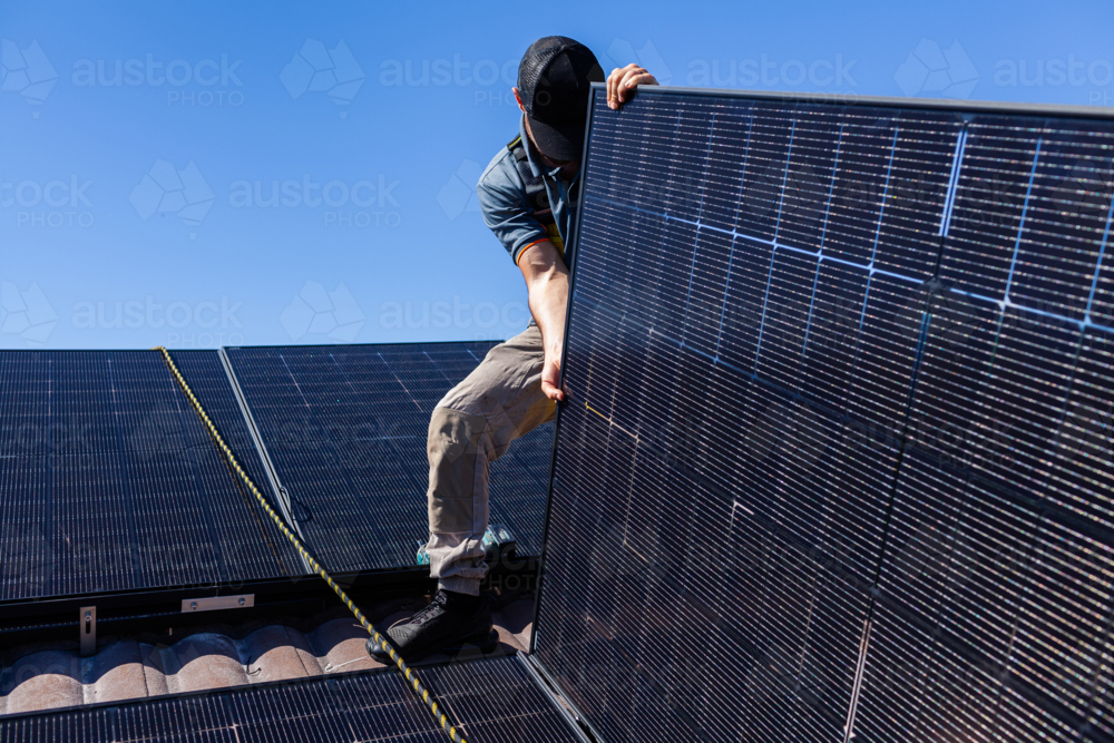 Image of Electrician tradie working on solar panel installation laying ...