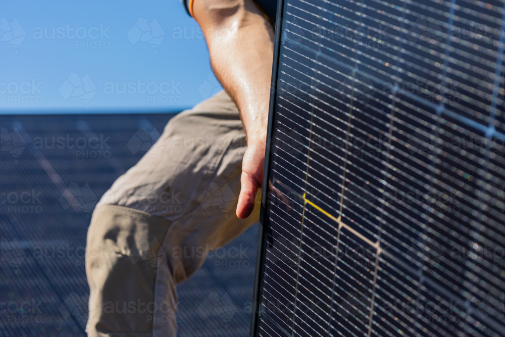 Image of Electrician tradie working on solar panel installation laying ...