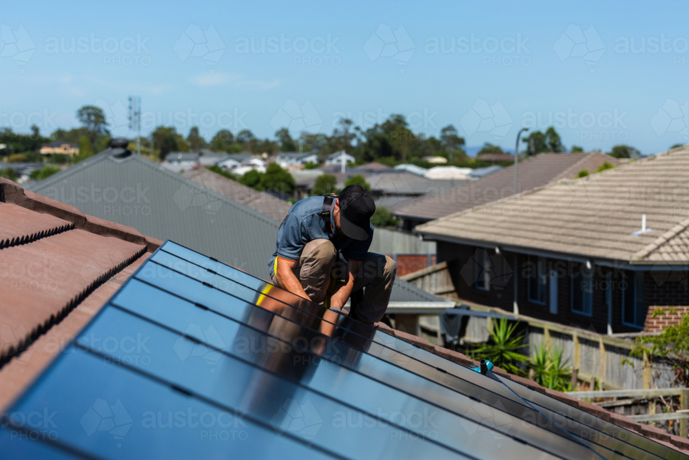 Image of Electrician tradie working on solar panel installation on roof ...