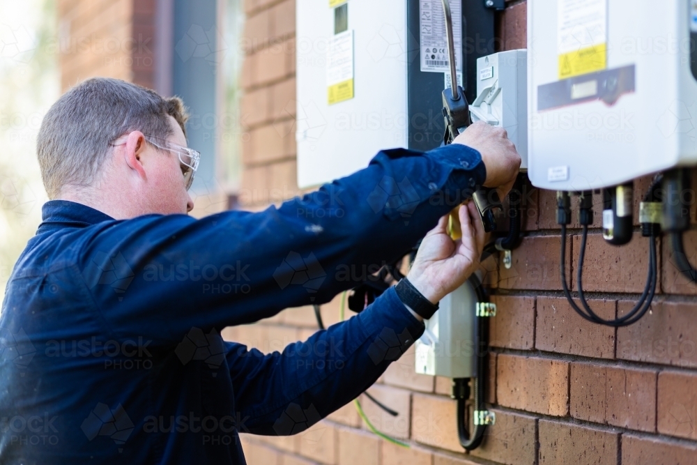 Image of Electrician using silicone glue gun to make electrical wiring