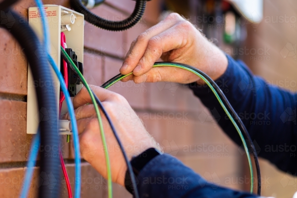 Electrician wiring wires while installing solar power on house : Austockphoto Electrician wiring wires while installing solar power on house - Australian Stock Image
