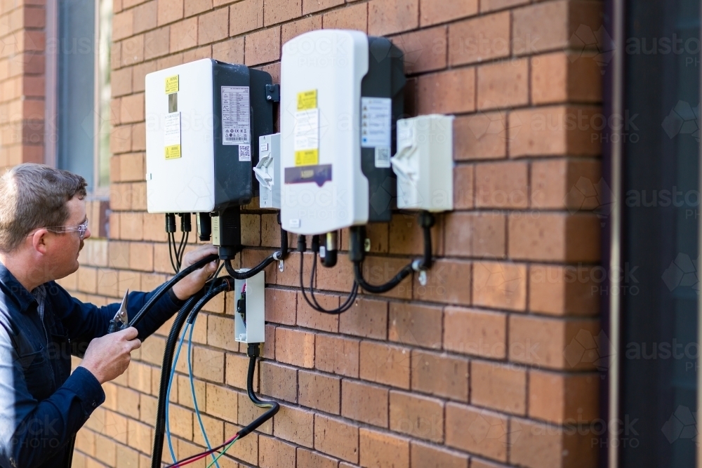 Image of Electrician wiring wires while installing solar power on house
