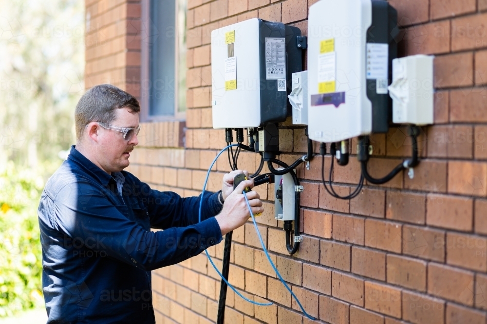 Image of Electrician wiring wires while installing solar power on house