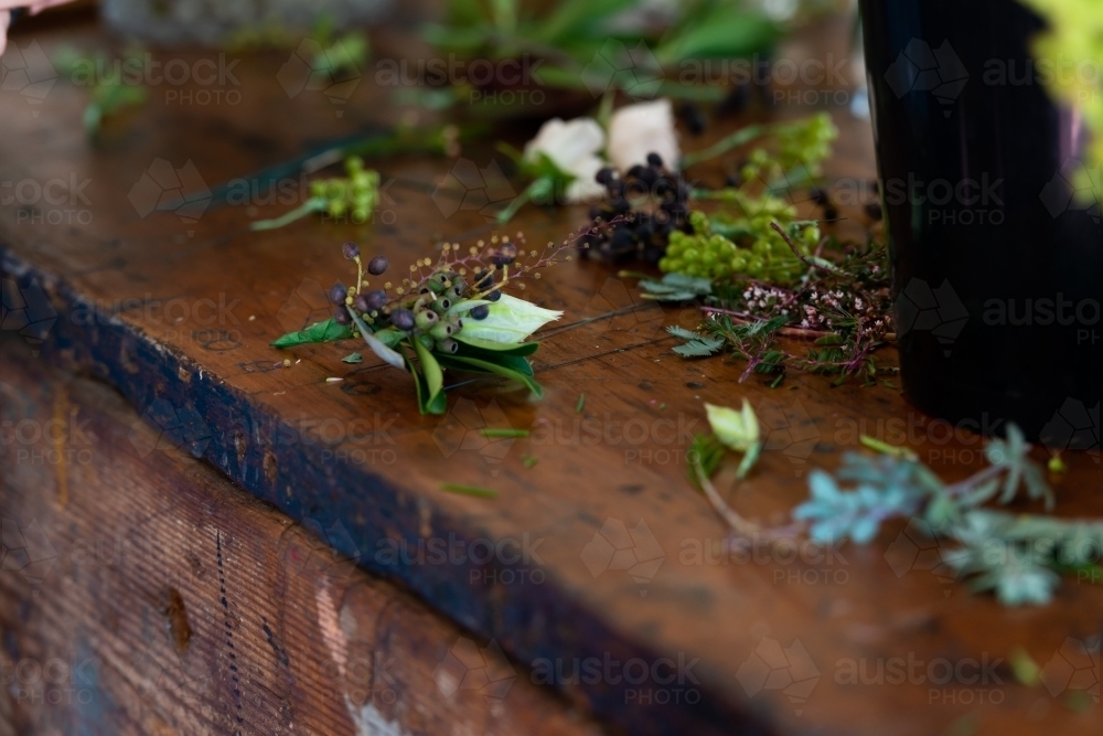 Elegant little wedding suit buttonhole or boutonnière on an old wooding work bench - Australian Stock Image