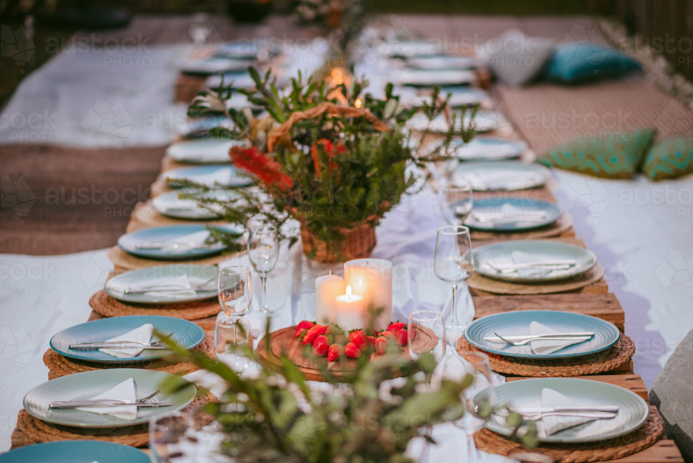 Elegant outdoor dining setup with natural decor and candlelight for a festive gathering - Australian Stock Image