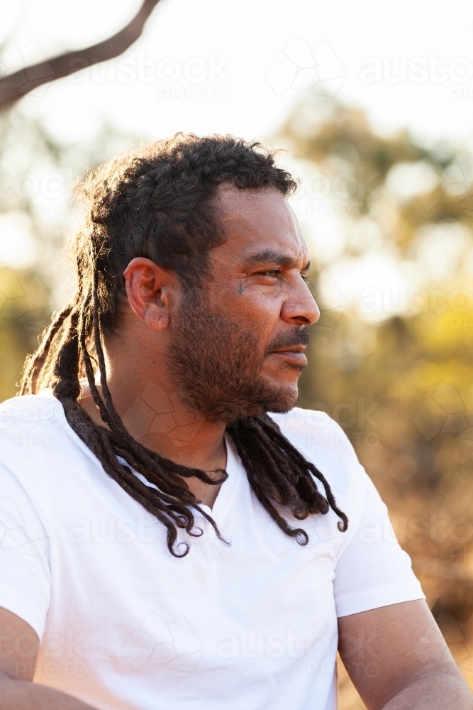 Emotionless face of first nations Australian man looking to side of frame in country - Australian Stock Image