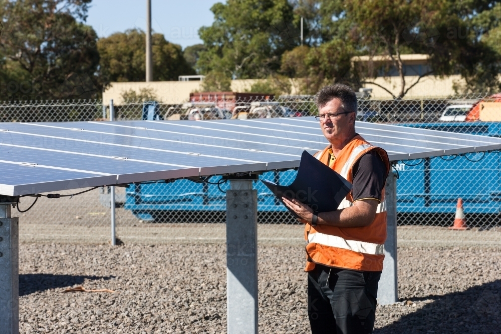 Employee taking notes at a Solar Panel plant - Australian Stock Image