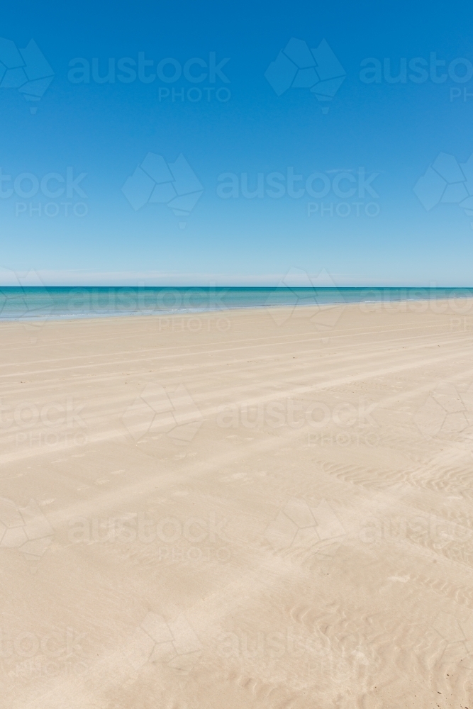 Empty beach with nothing but four wheel drive tyre tracks - Australian Stock Image