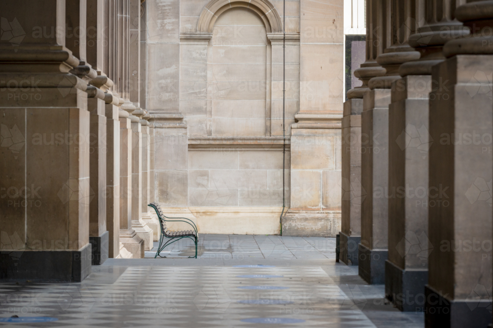 Image of Empty bench between sandstone columns in a historic urban ...