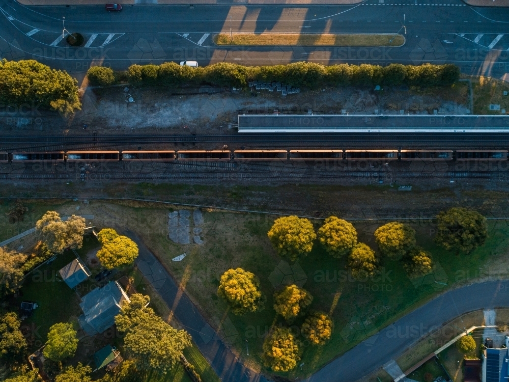 empty coal train casting long shadows in morning light from overhead aerial view - Australian Stock Image