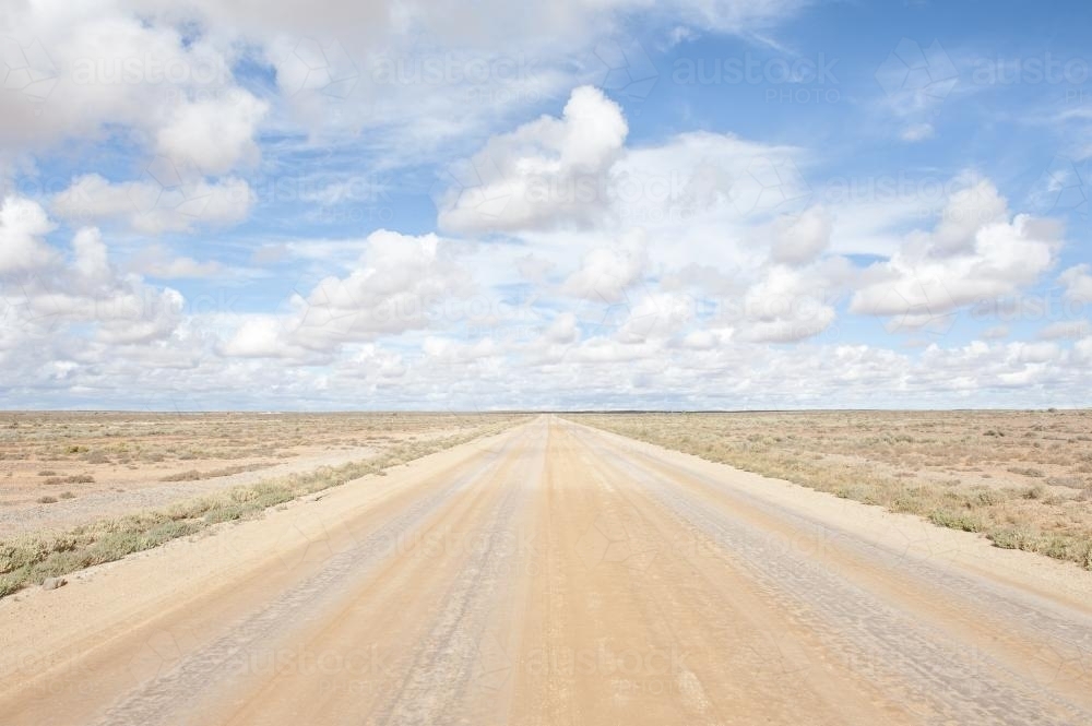 Empty straight dirt road leads to horizon - Australian Stock Image