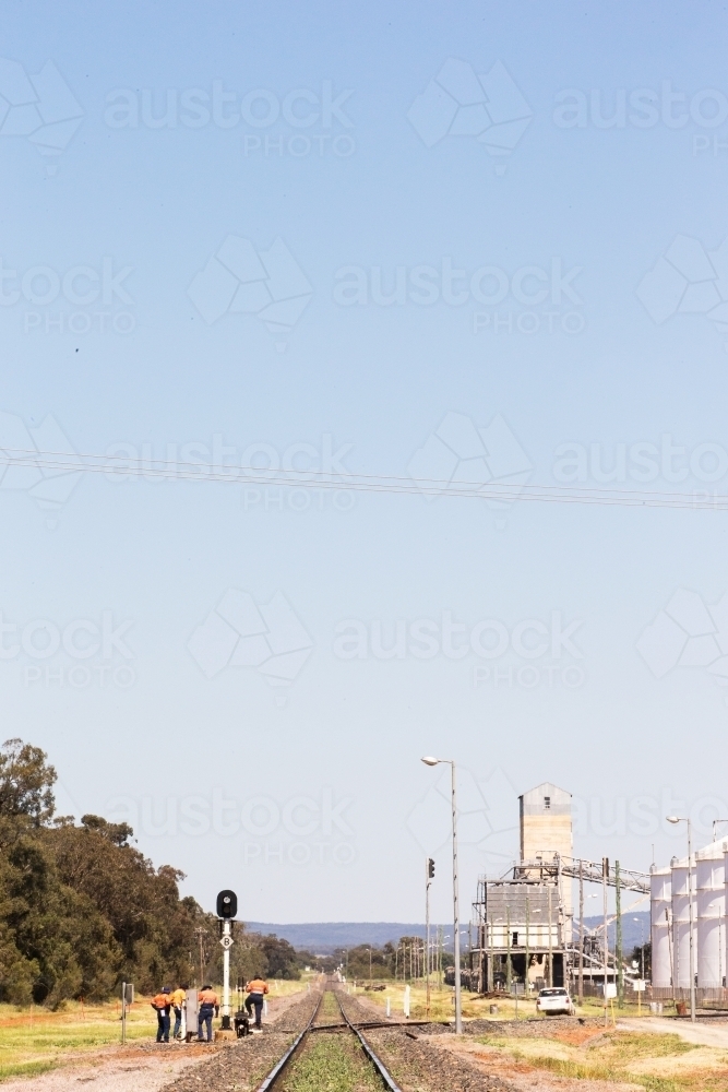 empty train line with railway workers trees and steel on the side with a blue sky and sunny day - Australian Stock Image