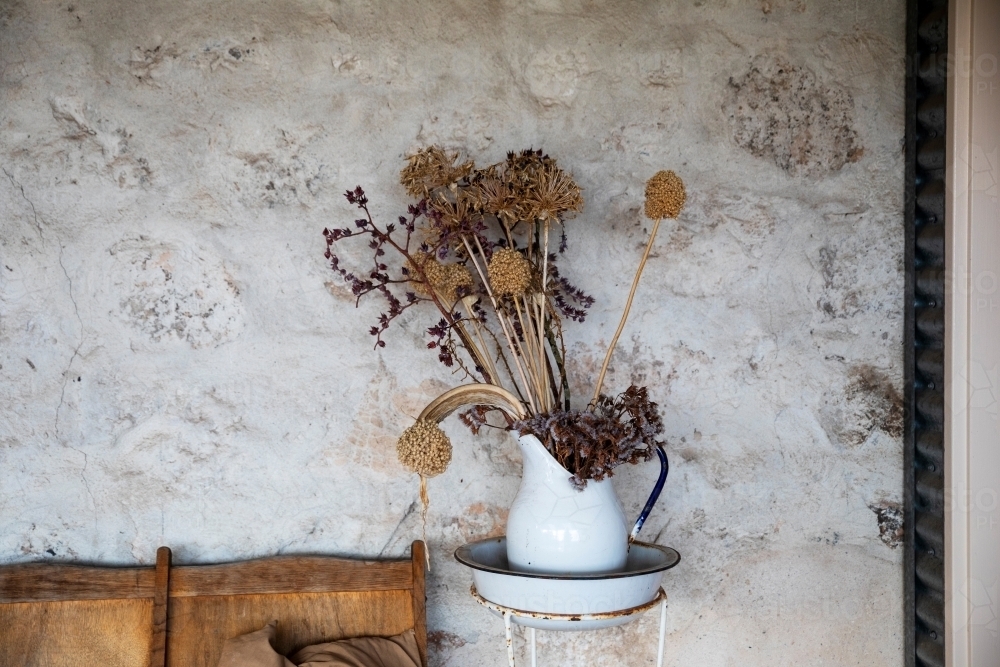 enamel jug with dried flower arrangement - Australian Stock Image
